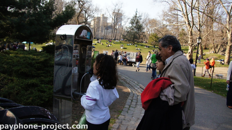 Little girl tries to use the abandoned Verizon payphone near Wollman Rink.
