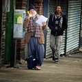 Bearded man talking on a payphone.