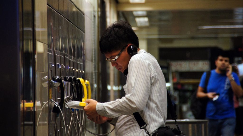 Man Attempting to Use a Penn Station Payphone